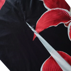 Close-up of red floral print on black fabric with slit detail and high-quality stitching