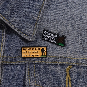 Funny Bigfoot enamel pins set on a denim jacket featuring creative silhouette designs