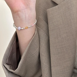 Detail of 925 sterling silver beaded bracelet with purple, orange, and pink decorative beads