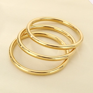 Detailed view of three 18k gold plated stainless steel bangles in minimalist style
