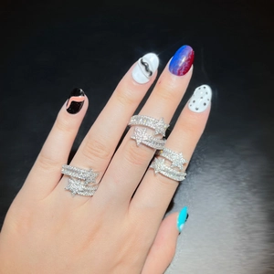 Adjustable silver star rings with pavé cubic zirconia worn on hand against black background