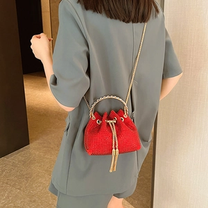 Sparkling red rhinestone bucket bag with gold ring handle and tassel details