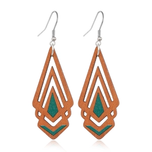 Close-up of geometric hollow wooden earrings in brown and green layered diamond design