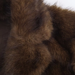 Détail de la texture en fausse fourrure marron foncé montrant des fibres de peluche douces