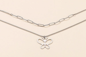 Detail view of silver double-layered necklace featuring paperclip chain and butterfly pendant