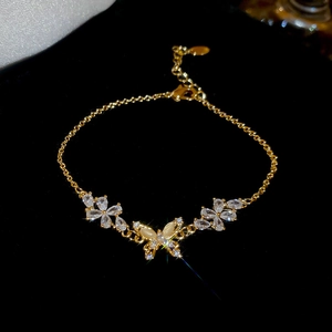 Detailed close-up of 18k gold plated butterfly and floral bracelet with white zircon