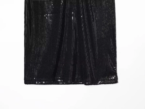 Close-up of black sequin dress hemline showing detailed stitching and shimmering texture