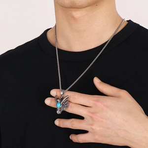 Macro view of male model wearing punk dragon pendant necklace with inlaid turquoise gemstone