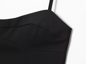 Détail d'une robe noire à fines bretelles montrant la texture du tissu tissé fin