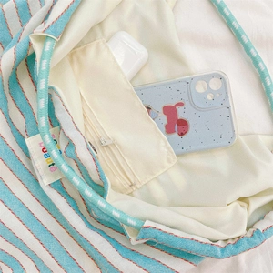 Detail view of striped canvas tote bag showing interior lining and zipper pocket