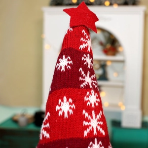 Close-up of a festive red striped knitted Christmas gnome hat with white snowflake patterns
