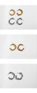 Detail of metal C-shaped hoop earrings with cube beads and snake chain texture