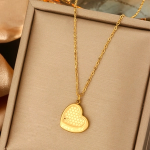 Detailed macro view of a gold heart pendant with honeycomb texture and Forever engraving
