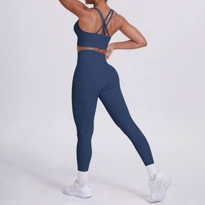 Dettaglio delle spalline incrociate del reggiseno e dei leggings yoga blu navy a vita alta