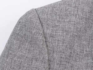 Detail of grey herringbone fabric texture and shoulder stitching on a women blazer suit