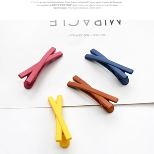Set of four colorful matte crisscross hair clips in red, blue, brown, and yellow shades