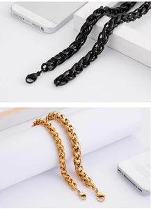 Close-up of black and gold titanium steel curb chains with lobster clasps and phone