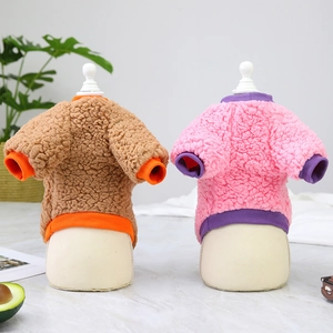 Detailed close-up of soft coral fleece pet sweaters in orange and pink bicolor patchwork