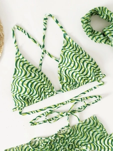 Detailed flat lay of green wave print bikini set with matching hair scrunchie