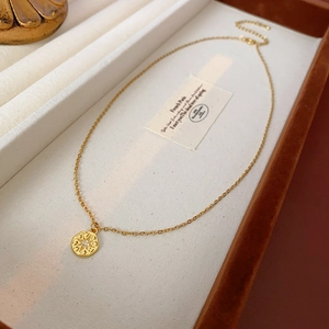 Détail d'un collier avec pendentif étoile dorée et zircon sur un plateau à bijoux