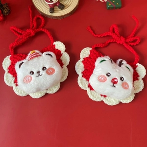 Detail of red and white woven Christmas pet bib featuring a plush bear on festive background