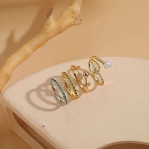 Macro detail of tulip and pearl rings with green zircons on a textured pedestal