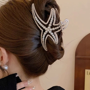 Elegant silver starfish hair claw clip with pearls and rhinestones on woman hair
