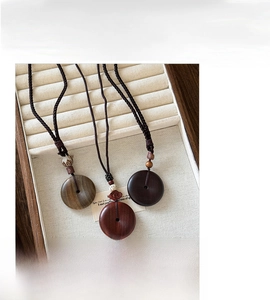 Primer plano de collar con colgante de madera retro con cordón trenzado y vetas de madera