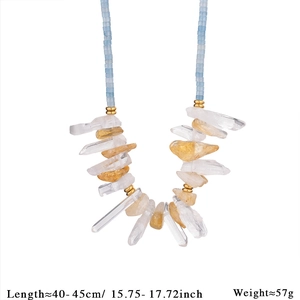 Macro detail of natural crystal beads and yellow stone pendant on stainless steel necklace