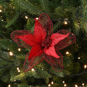 Red 23cm glitter artificial Christmas flower hanging on a green tree with warm lights