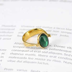 Nahaufnahme eines goldfarbenen Rings mit gehämmertem Metall und grünem Edelstein
