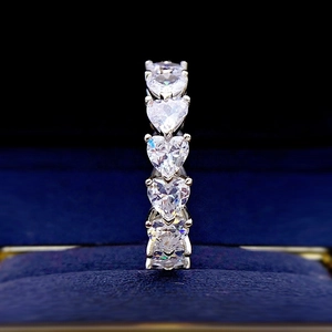 Macro shot of silver eternity ring with heart-cut stones in a blue velvet box