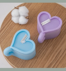 Macro shot of blue and purple heart-shaped scented candles on a rustic wooden tray