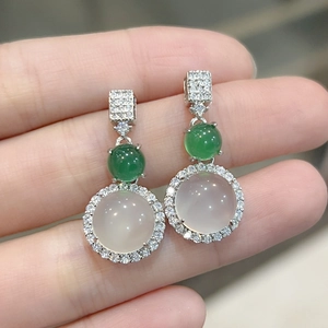 Close-up of silver earrings with green jade, white chalcedony and diamond accents