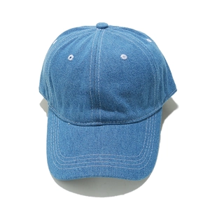 Detail of light blue denim baseball cap showing white contrast stitching and texture