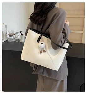 Vista dettagliata della borsa tote bianca minimalista con tracolle nere a contrasto