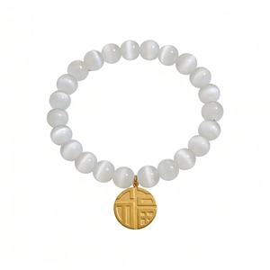 Translucent cat eye stone bead bracelet with a golden Fu pendant on white background