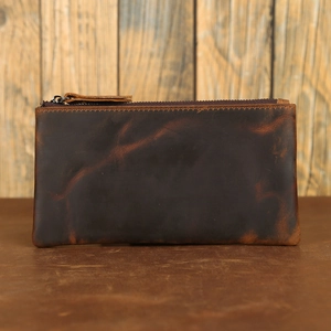 Detail of dark brown crazy horse leather wallet with vintage texture on a rustic surface