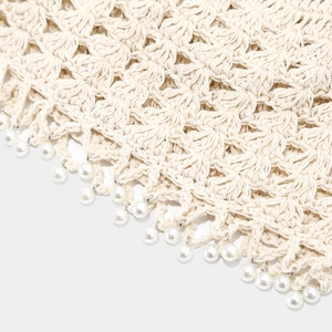 Close-up of handmade crochet hollow knit hat with delicate white pearl pendant tassels