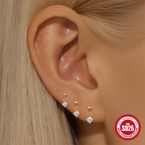 Three gold S925 sterling silver stud earrings with sparkling cubic zirconia on model
