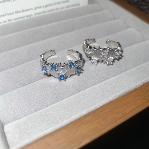 Detailed macro shot of irregular textured silver rings with blue and white zircons