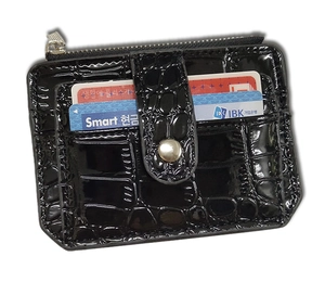 Detail of black crocodile texture card holder with zipper pocket and snap button strap