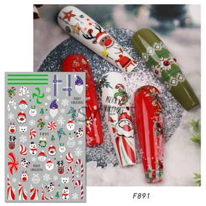 Detail of Christmas nail stickers with Santa and reindeer patterns on colored nails