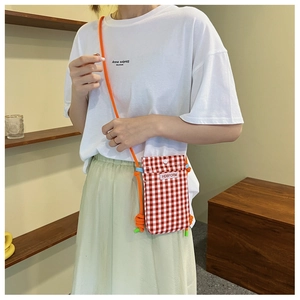 Detail of red and white checkered crossbody phone bag with orange rope strap on a model