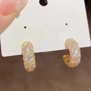 Sparkling gold C-shaped hoop earrings featuring micro-paved cubic zirconia accents