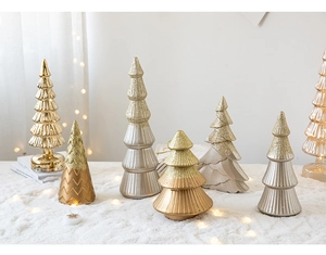 Miniature gold and silver glitter Christmas trees on snow mat with warm lights
