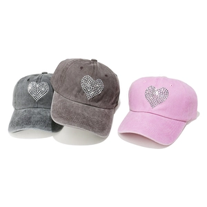 Detailed view of washed cotton baseball caps with rhinestone heart in gray and pink