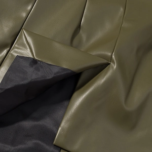 Close-up of olive green PU leather texture with high-quality stitching and black lining