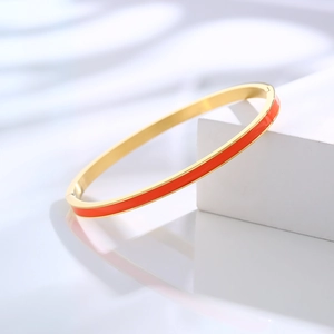 Detail of red enamel gold-plated stainless steel minimalist bangle on geometric stand