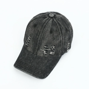 Detailed view of distressed washed denim baseball cap with vintage frayed brim details